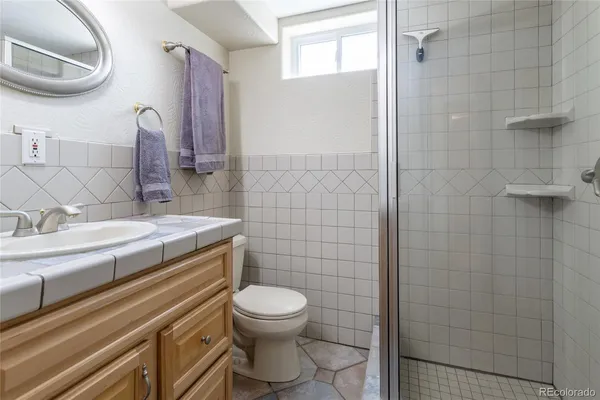 a bathroom with a granite countertop toilet a sink and mirror