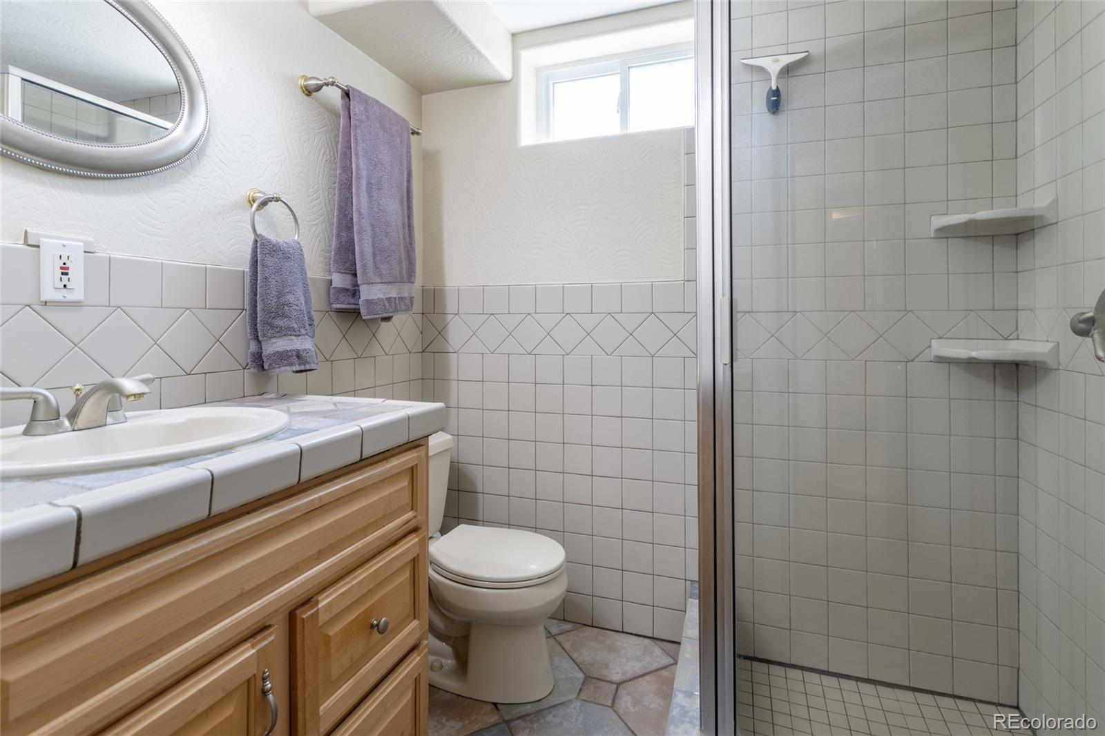 4530 South Inca Street Englewood, CO 80110 - Photo 28 of 37 a bathroom with a granite countertop toilet a sink and mirror