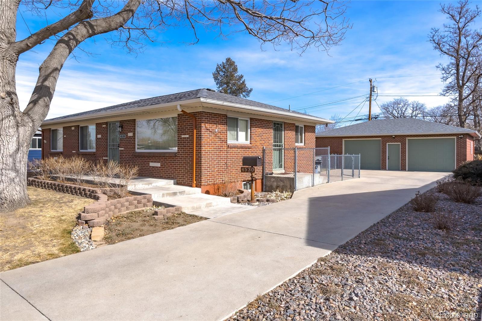 4530 South Inca Street Englewood, CO 80110 - Photo 4 of 37 a front view of a house with a yard and potted plants