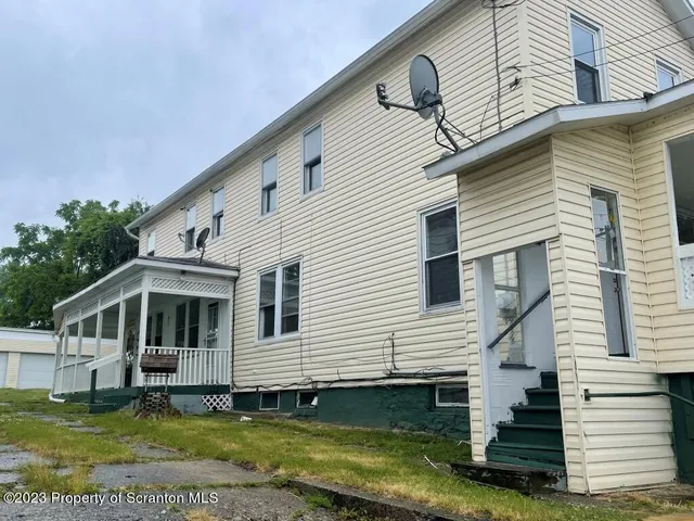 a view of a white house with a big yard and a large window