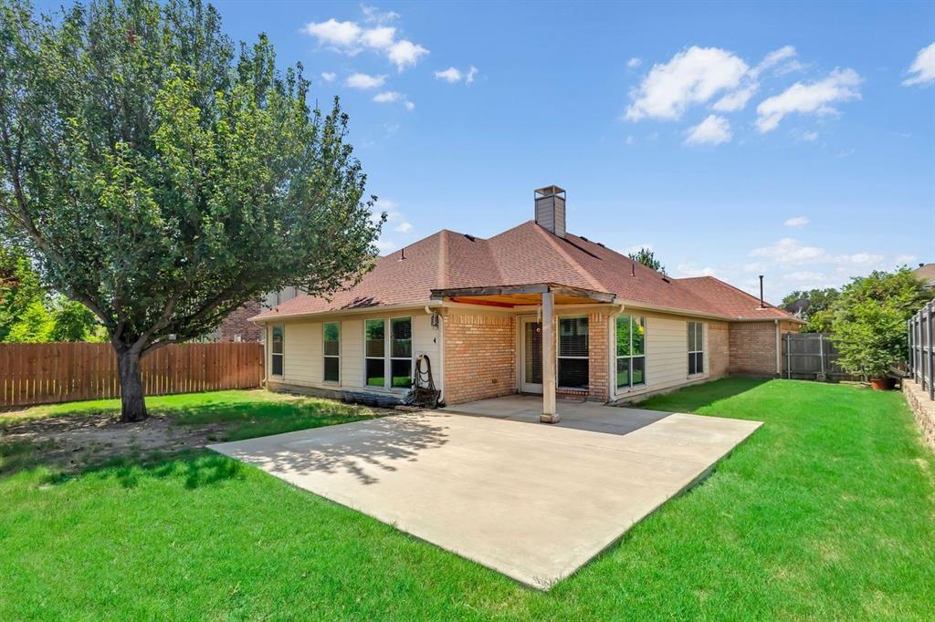 5316 Ridgeson Drive McKinney, TX 75071 - Photo 31 of 33 Spacious backyard featuring a large concrete patio, manicured lawn, mature tree, and privacy fencing