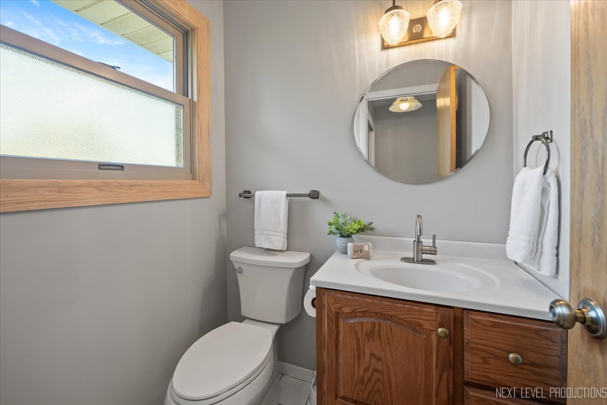 3011 Scenicwood Lane Woodridge, IL 60517 - Photo 13 of 21 a bathroom with a toilet a sink and mirror