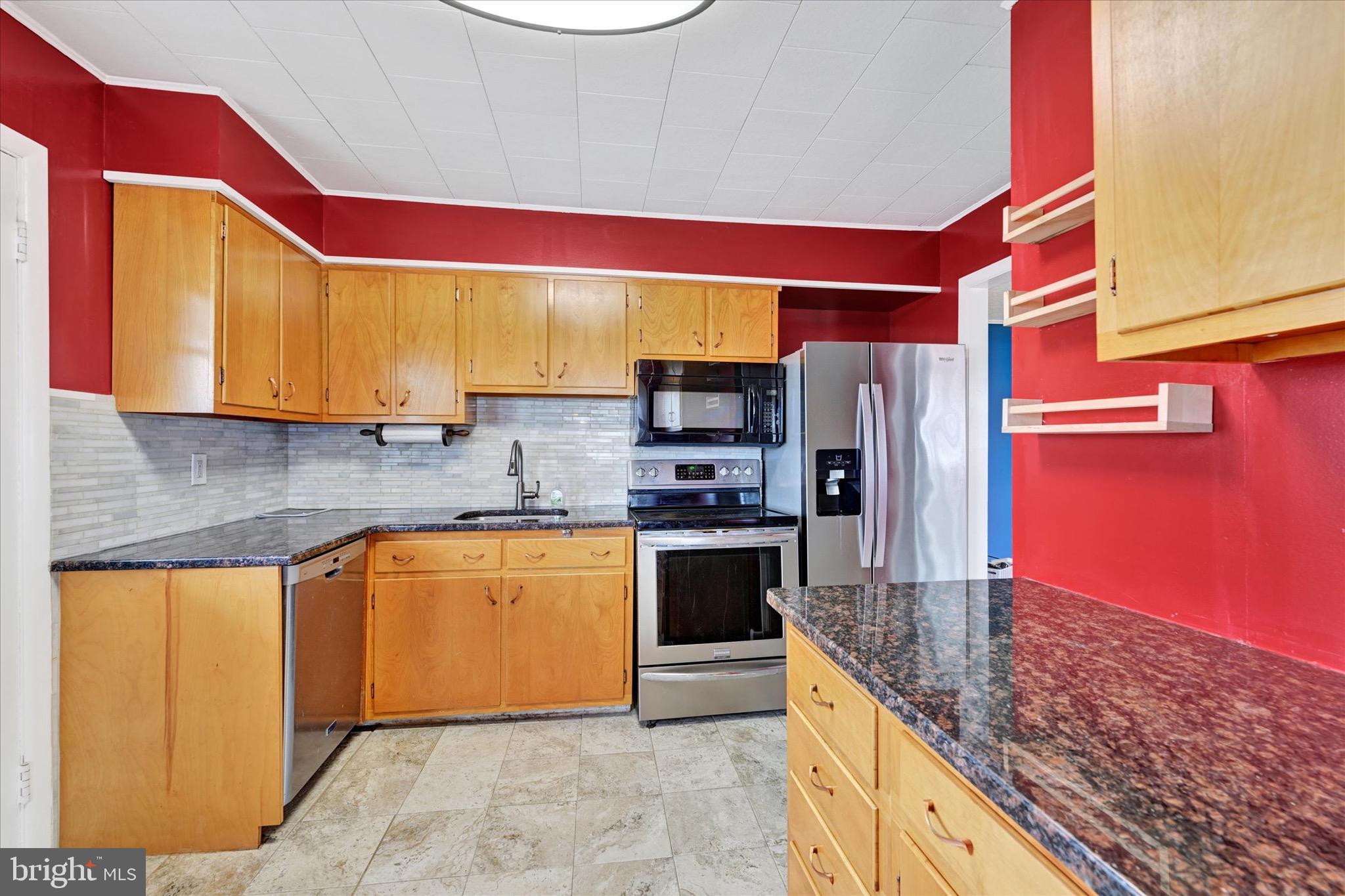 563 Compass Road East Baltimore, MD 21220 - Photo 8 of 23 a kitchen with stainless steel appliances granite countertop a refrigerator and a stove