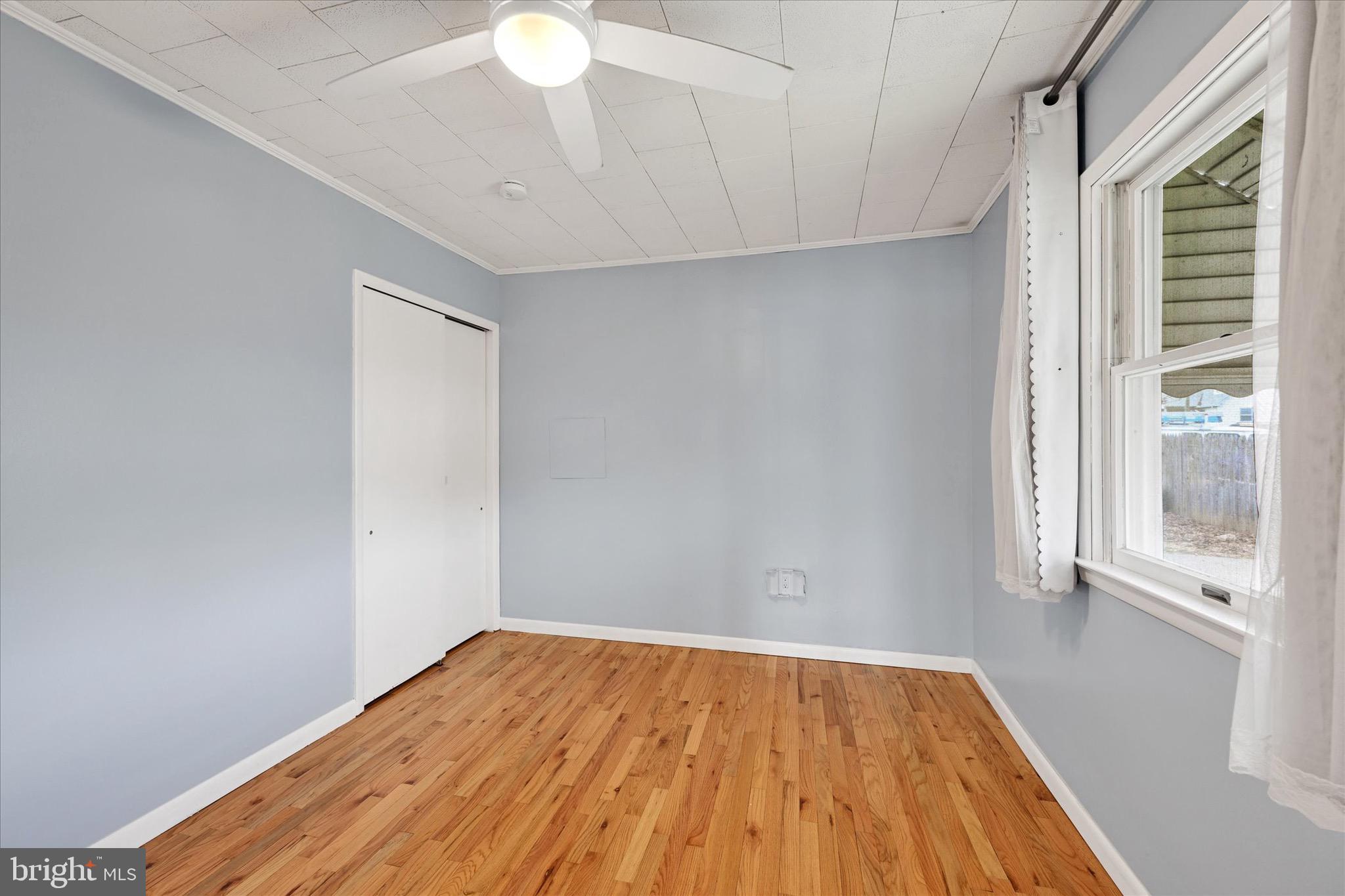 563 Compass Road East Baltimore, MD 21220 - Photo 9 of 23 a view of empty room with wooden floor and fan