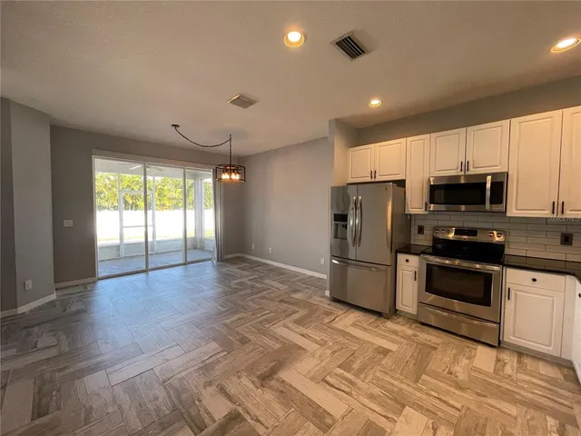 a kitchen with stainless steel appliances granite countertop a sink and stove top oven