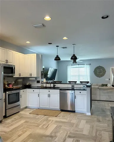 a view of a kitchen with stainless steel appliances granite countertop a refrigerator and a sink