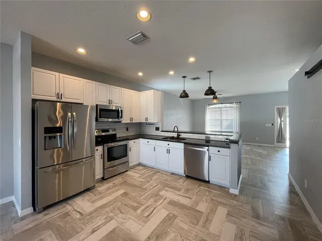 a kitchen with stainless steel appliances granite countertop a refrigerator and microwave