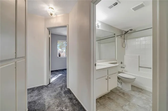 a bathroom with a double vanity sink toilet mirror and shower