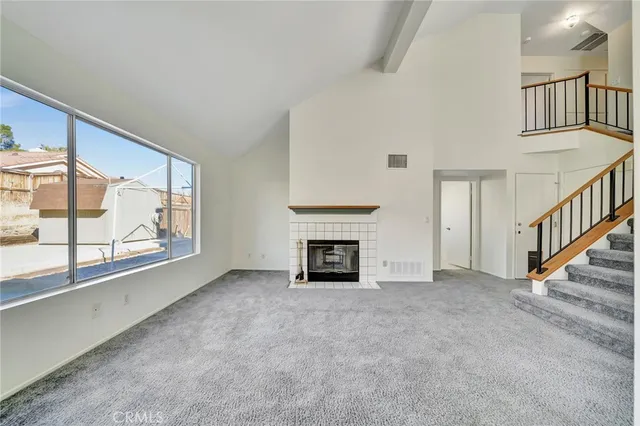 an empty room with floor to ceiling windows and a fireplace