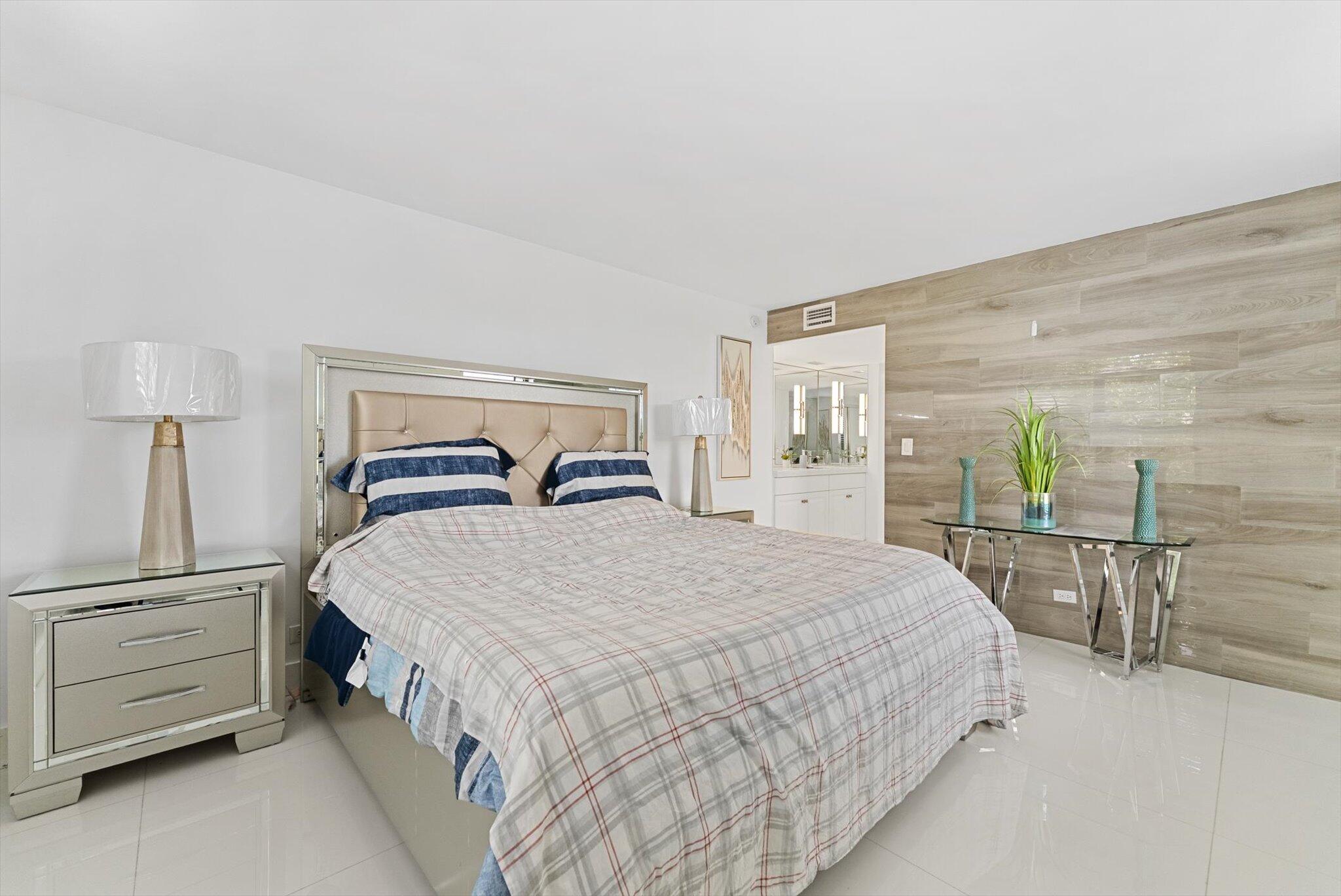 3730 Inverrary Drive, Unit 2L Lauderhill, FL 33319 - Photo 15 of 17 a bedroom with a bed a table and chair