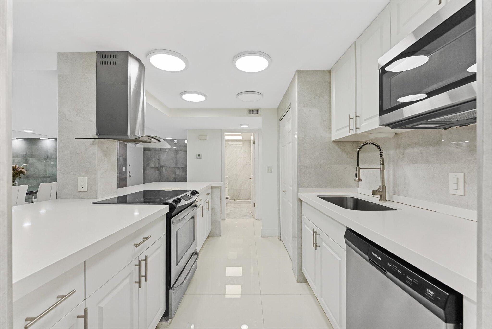 3730 Inverrary Drive, Unit 2L Lauderhill, FL 33319 - Photo 9 of 17 a kitchen with a sink stove and cabinets