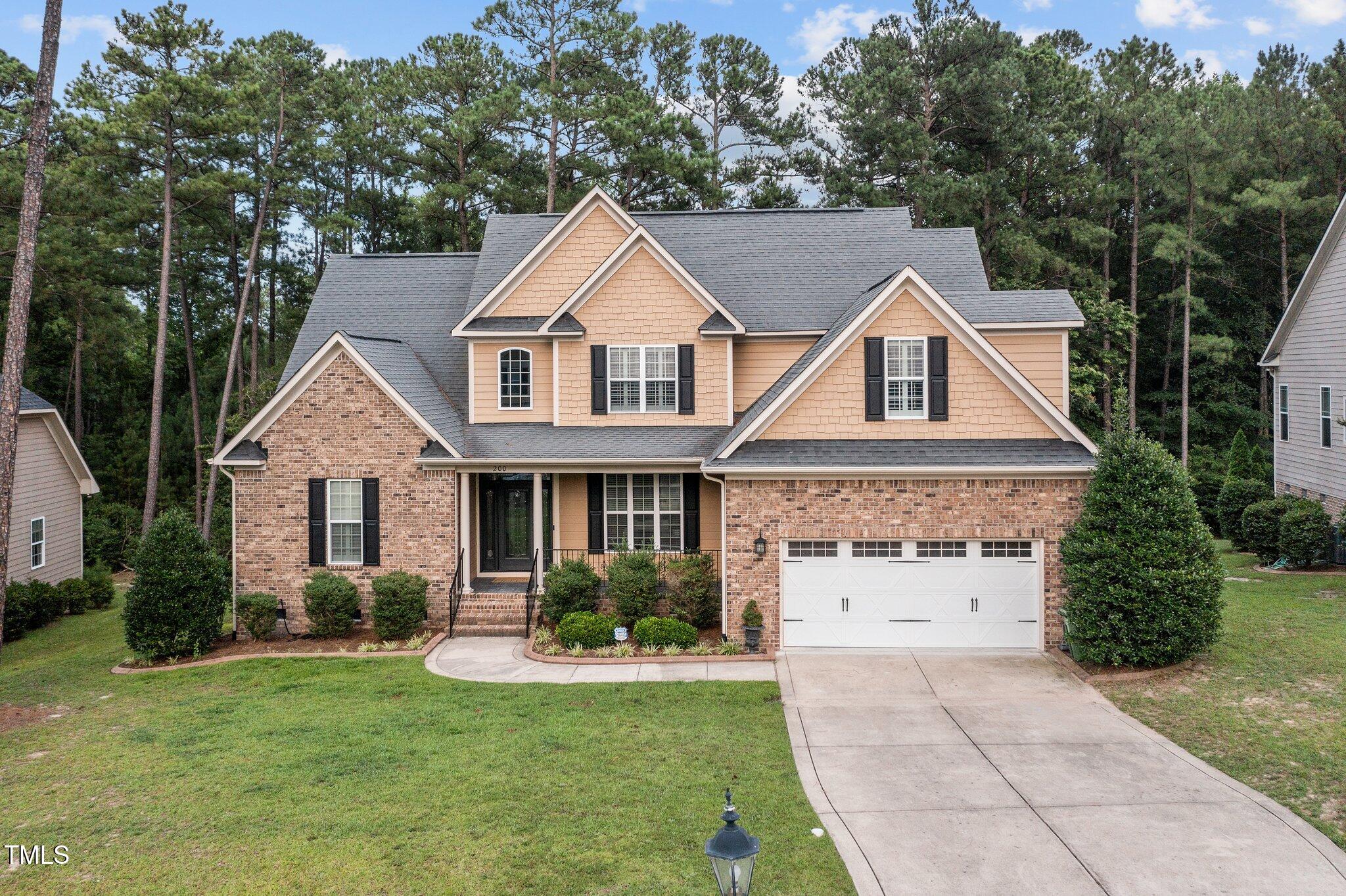 a front view of a house with a yard and trees