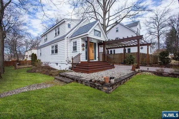 a view of a house with backyard and a tree