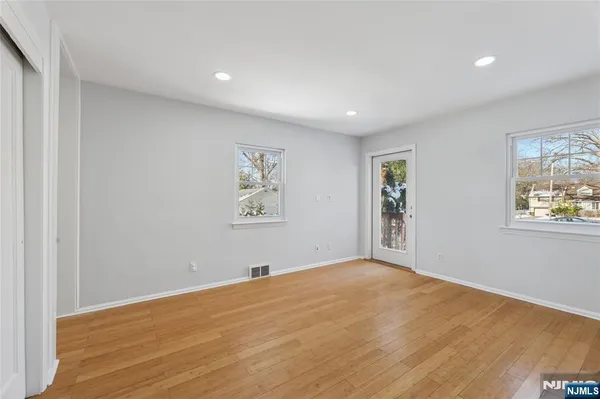 a view of empty room with wooden floor