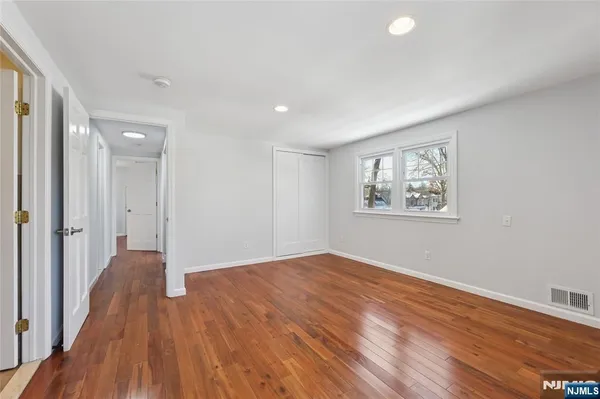 a view of a big room with wooden floor and windows