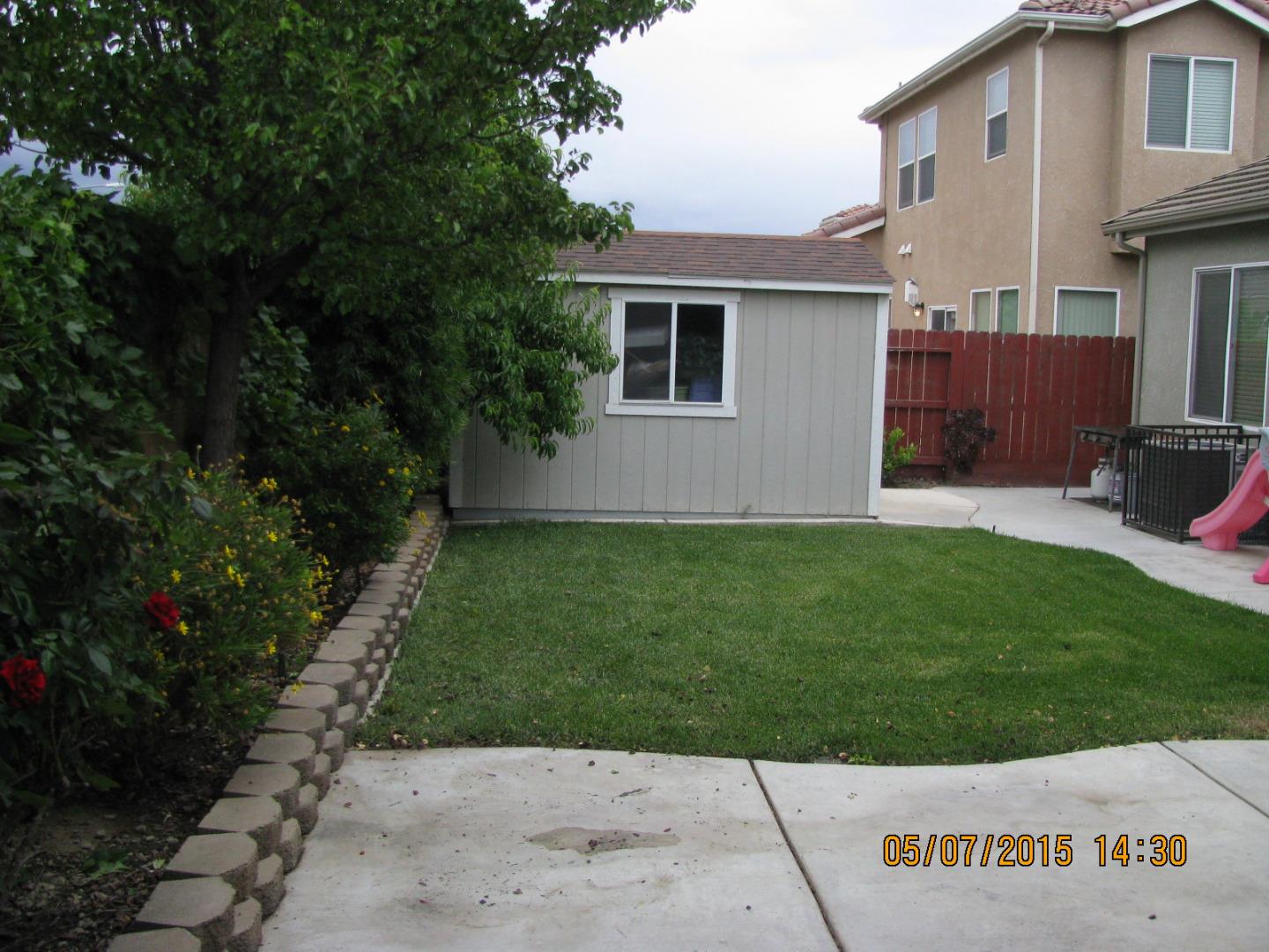 911 Azalea Court Los Banos, CA 93635 - Photo 3 of 5 a backyard of a house with a garden and barbeque oven