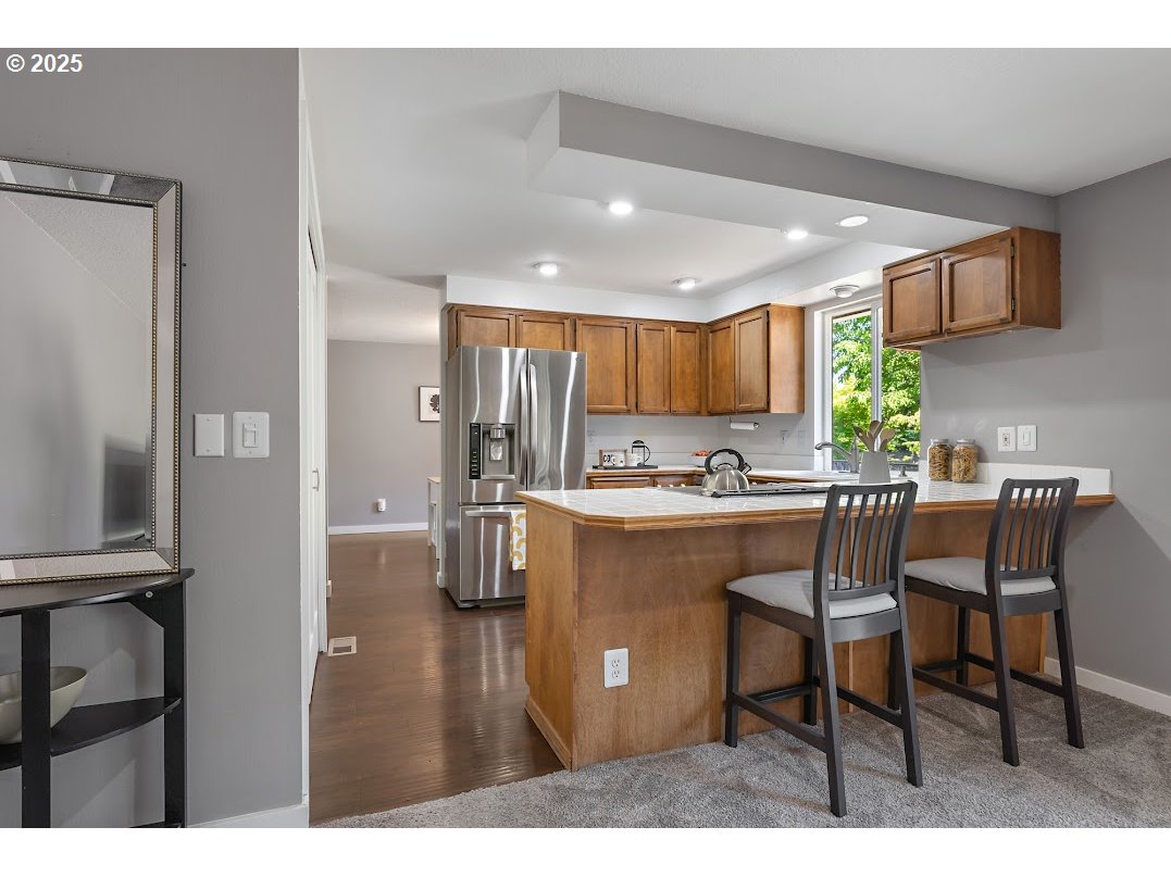 11595 Southwest Fairview Lane Tigard, OR 97223 - Photo 11 of 46 a kitchen with a table chairs refrigerator and microwave
