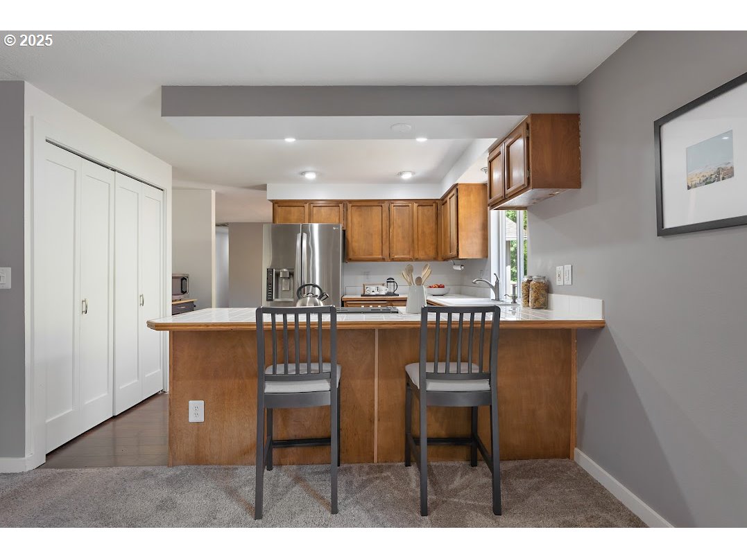 11595 Southwest Fairview Lane Tigard, OR 97223 - Photo 14 of 46 a kitchen with kitchen island granite countertop a sink cabinets and wooden floor