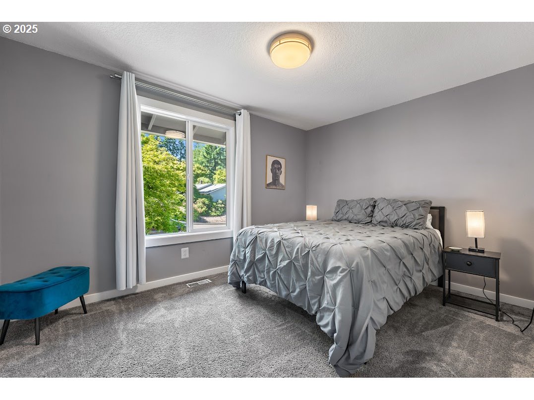 11595 Southwest Fairview Lane Tigard, OR 97223 - Photo 27 of 46 a spacious bedroom with a bed and a window