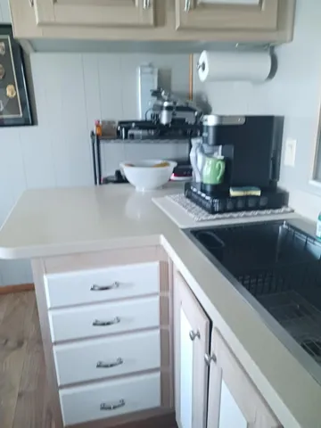 a kitchen with a sink and a stove with wooden floor