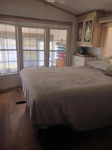 a bed sitting in a bedroom next to a window