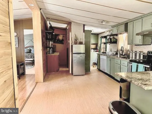 a kitchen with stainless steel appliances kitchen island granite countertop a refrigerator and stove