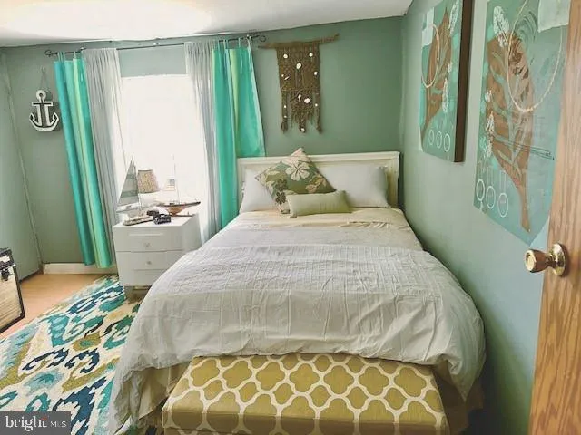 a bedroom with a bed and a painting on the wall