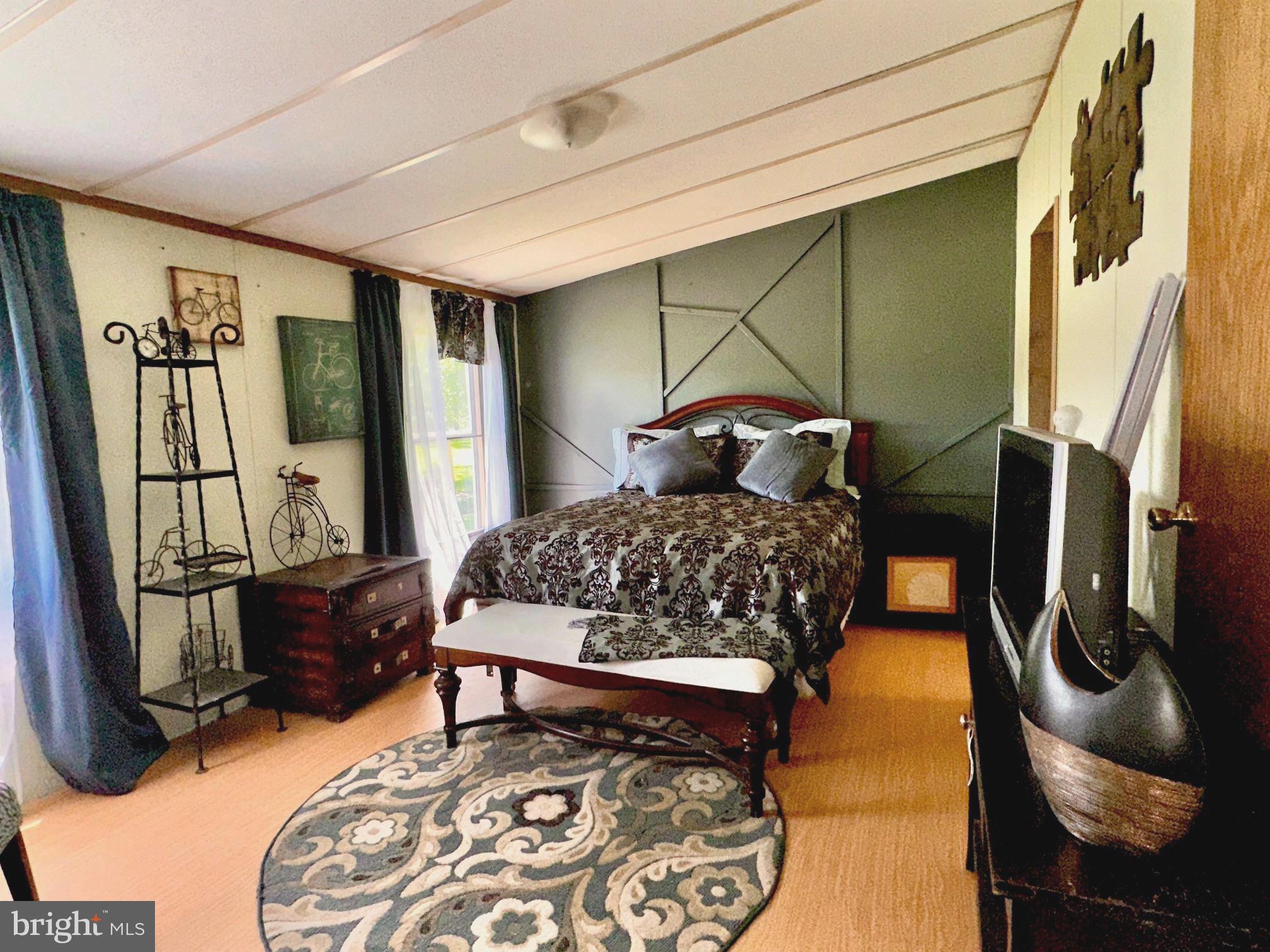 4770 Daughertytown Road, Unit B Crisfield, MD 21817 - Photo 8 of 9 a bedroom with a bed and wooden floor