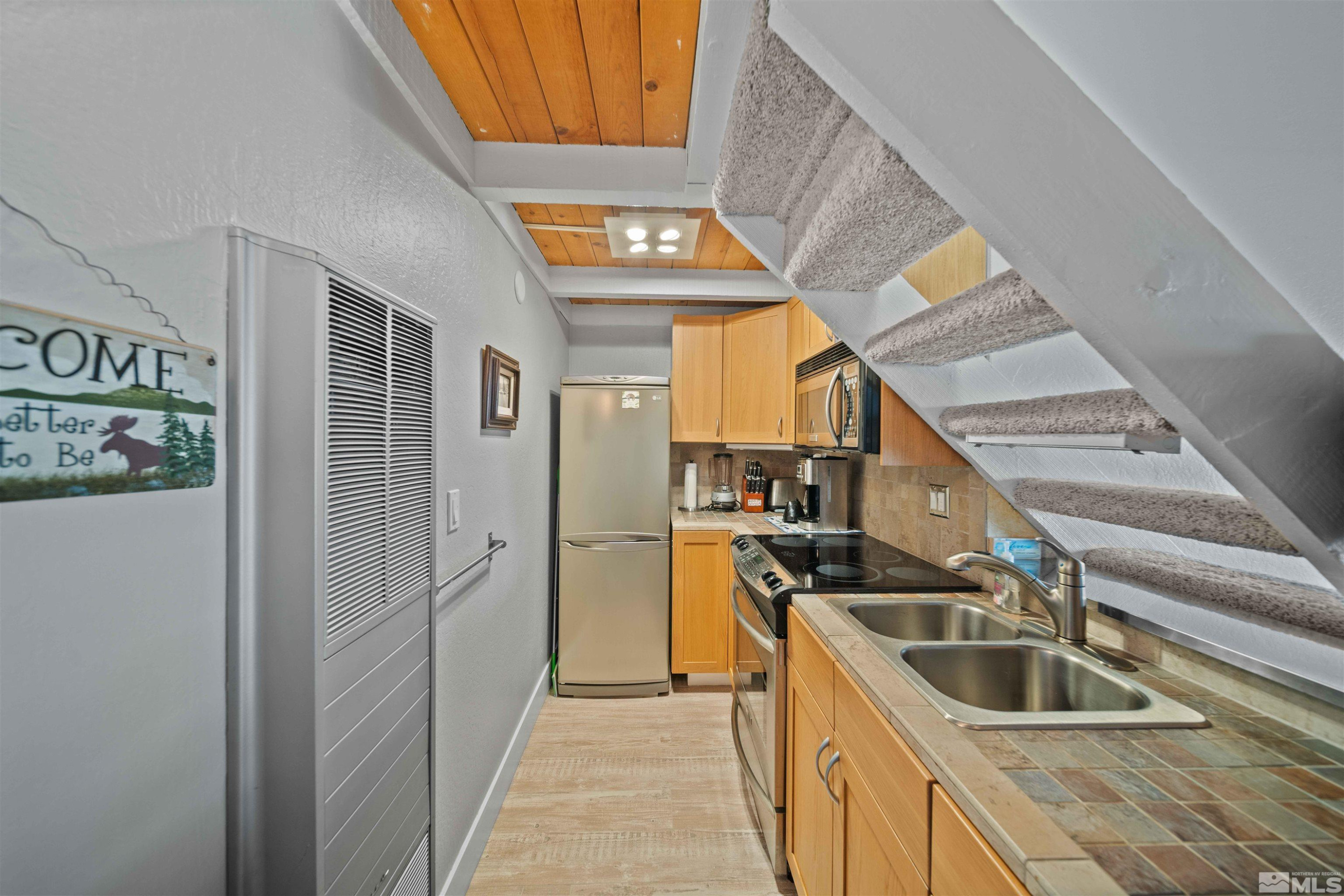331 Tramway Drive, Unit 26 Stateline, NV 89449 - Photo 7 of 27 a kitchen that has a sink cabinets counter space and stainless steel appliances