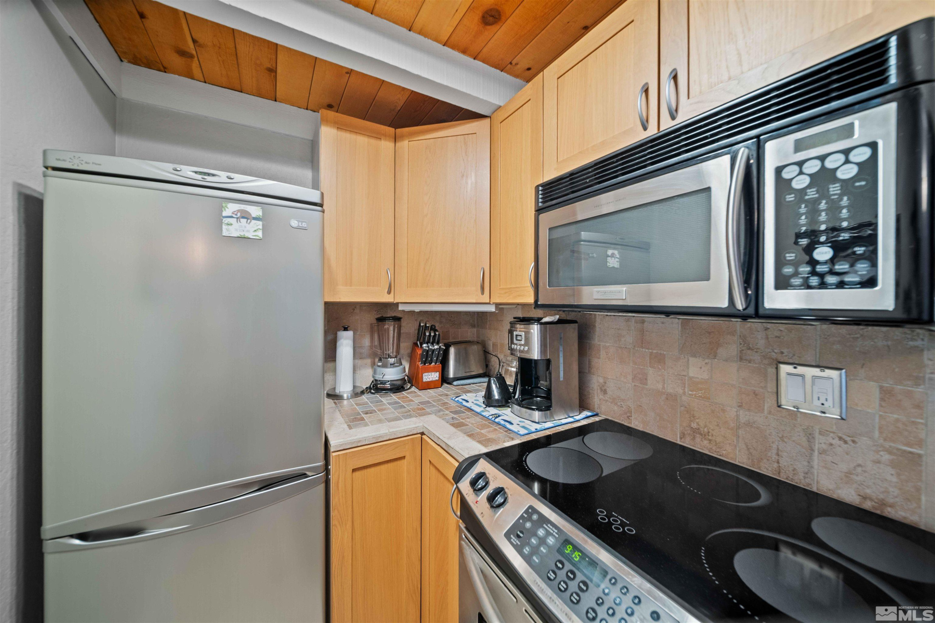 331 Tramway Drive, Unit 26 Stateline, NV 89449 - Photo 8 of 27 a kitchen with stainless steel appliances granite countertop a refrigerator a sink and a stove