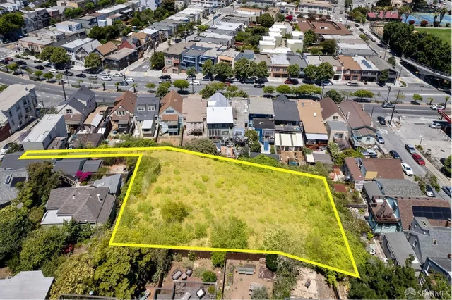 an aerial view of a swimming pool with outdoor seating and yard