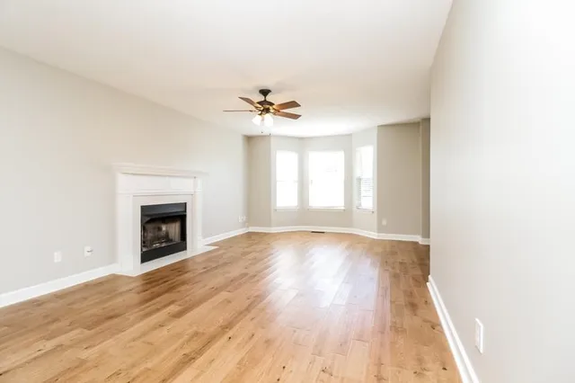an empty room with wooden floor and fireplace