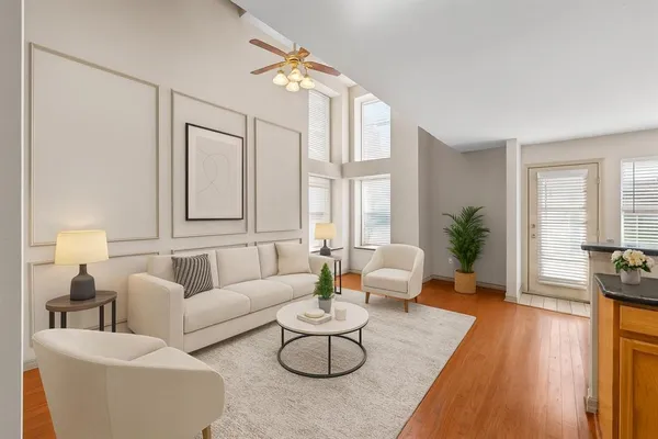 a living room with furniture potted plant and a large window