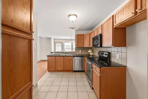 a kitchen with stainless steel appliances granite countertop a refrigerator and a stove top oven