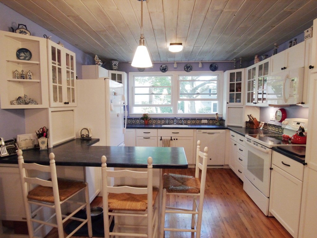 53 Overlook Road Marblehead, MA 01945 - Photo 5 of 24 a kitchen with granite countertop a stove a sink and white cabinets with wooden floor