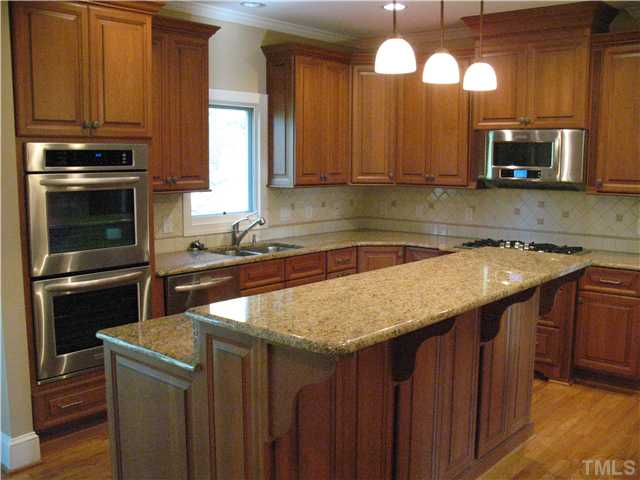 4105 John S Raboteau Wynd Raleigh, NC 27612 - Photo 6 of 20 a kitchen with stainless steel appliances wooden cabinets a sink and a stove