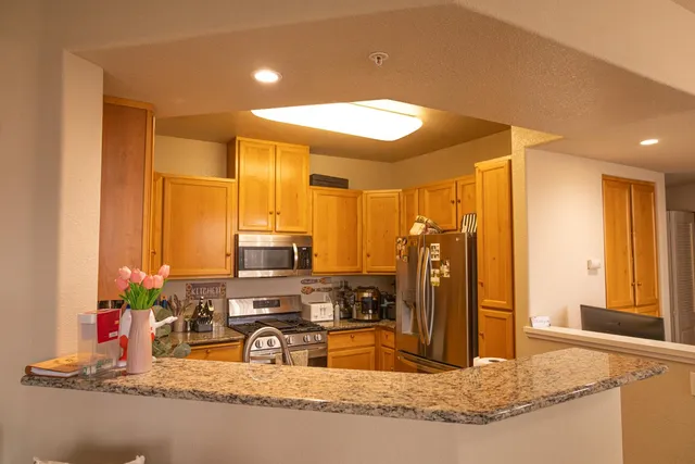 a kitchen with kitchen island granite countertop a sink and cabinets