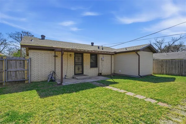 a view of a house with a yard and wooden fence