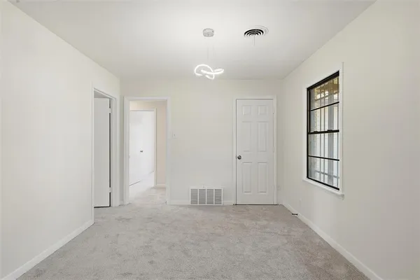 an empty room with closet and windows