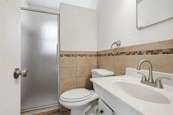 a bathroom with a sink a toilet and shower