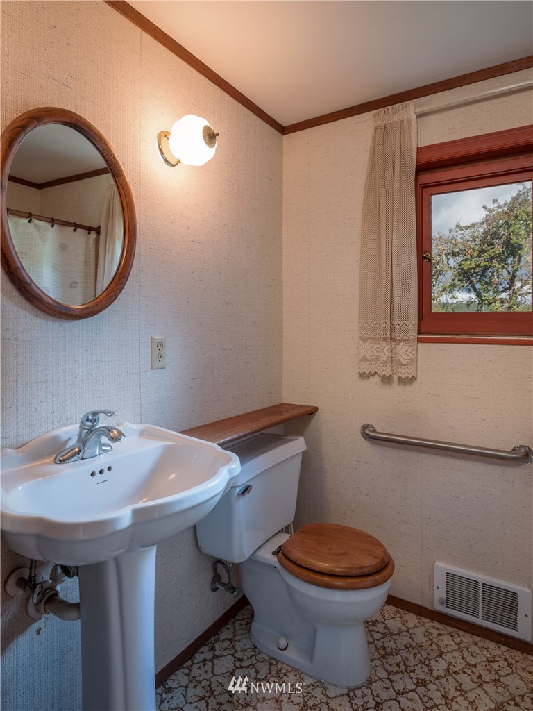 1428 Aleck Bay Road Lopez Island, WA 98261 - Photo 15 of 30 a bathroom with a sink a toilet and a mirror