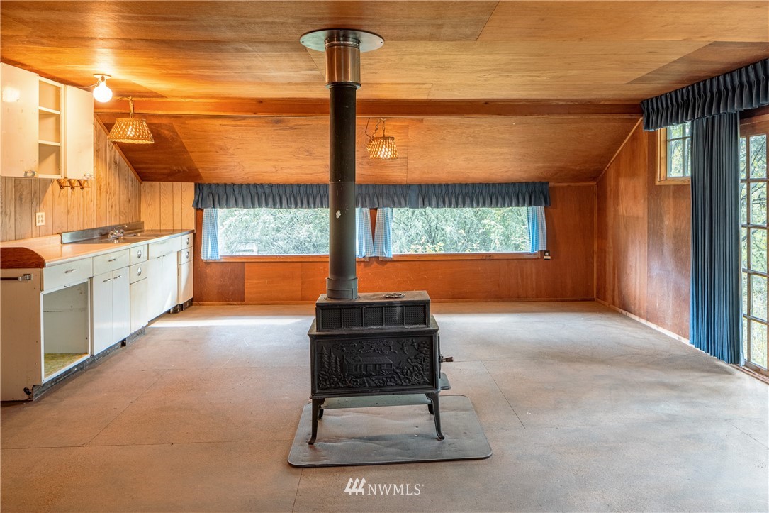 1428 Aleck Bay Road Lopez Island, WA 98261 - Photo 23 of 30 a living room filled with furniture and a floor to ceiling window