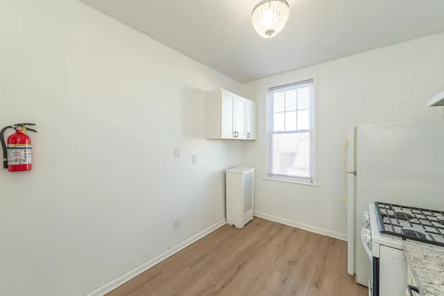 an empty room with windows and cabinet