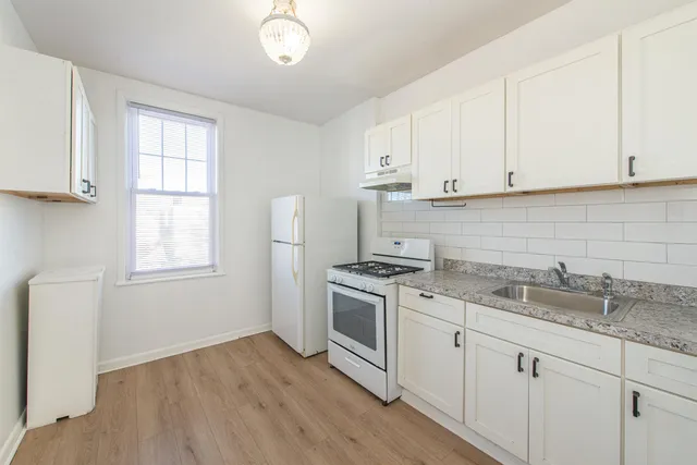a kitchen with granite countertop white cabinets and a stove