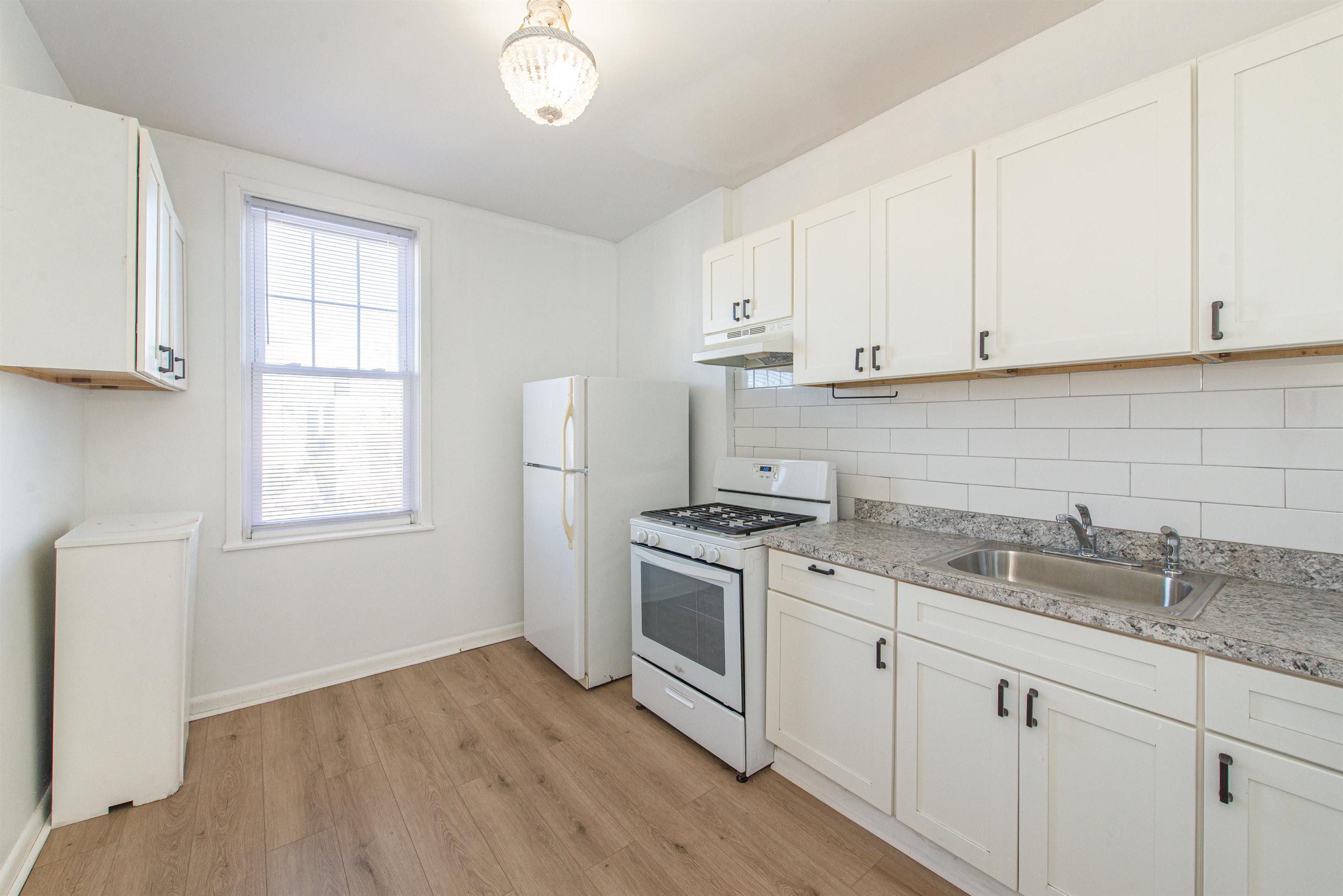 1308 27th Street, Unit 2 North Bergen, NJ 07047 - Photo 9 of 15 a kitchen with granite countertop white cabinets and a stove