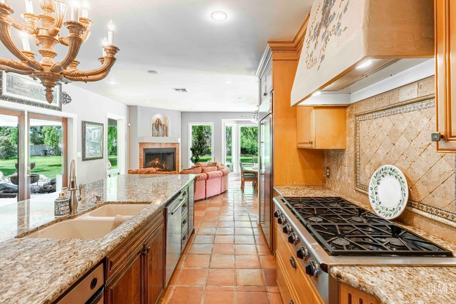 Undisclosed Address Bakersfield, CA 93314 - Photo 19 of 67 a kitchen with kitchen island granite countertop a stove a large window cabinets and a dining table