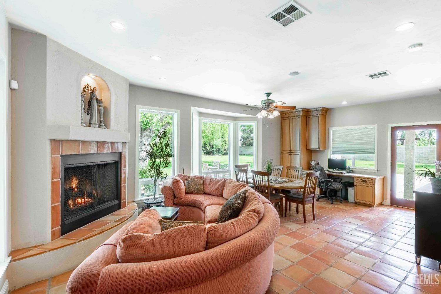 Undisclosed Address Bakersfield, CA 93314 - Photo 23 of 67 a living room with furniture potted plant floor to ceiling window and a fireplace