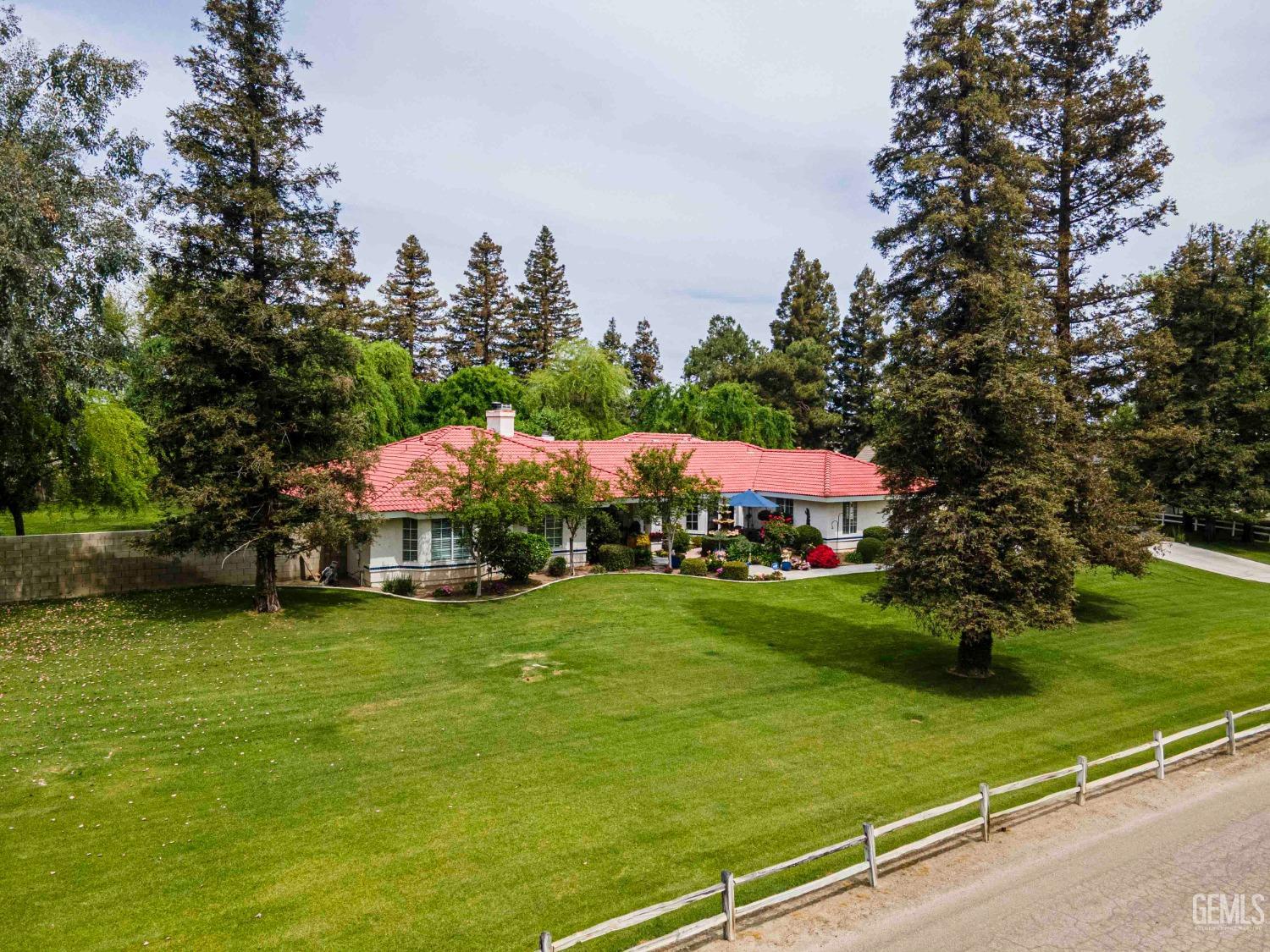 Undisclosed Address Bakersfield, CA 93314 - Photo 62 of 67 a view of a garden with a building and trees in the background