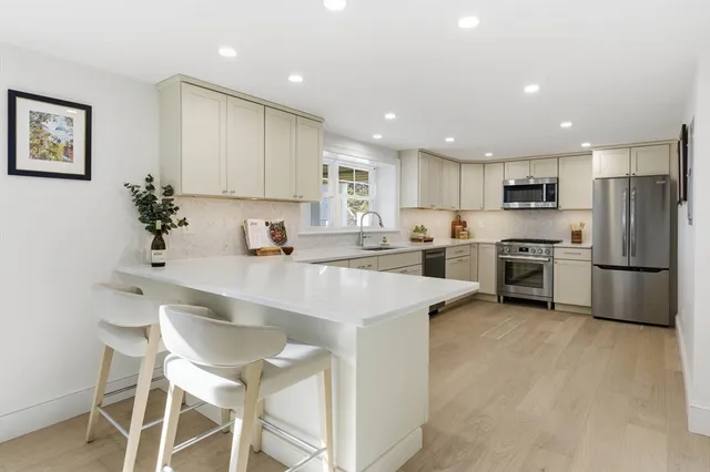 a kitchen with a sink stainless steel appliances and white cabinets