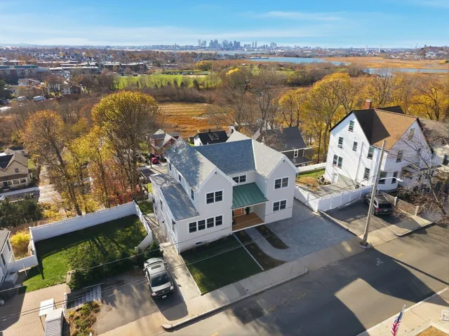 an aerial view of residential houses with outdoor space and ocean view